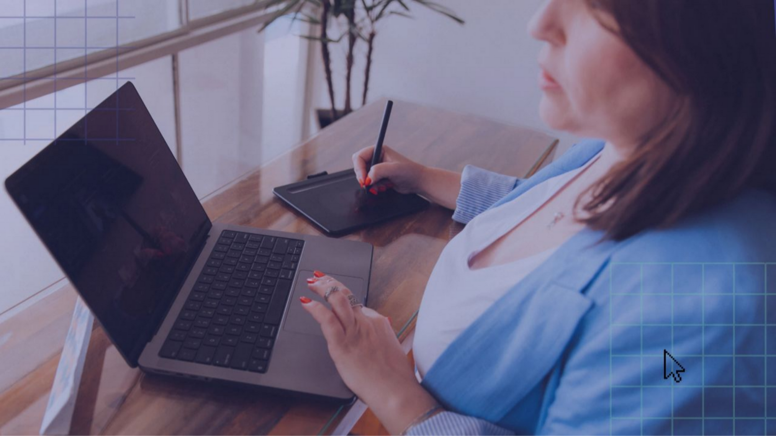 Carla Toscano Pós-Produção Fotográfica trabalhando em edição de imagens com notebook e mesa digitalizadora, vestindo blazer azul.